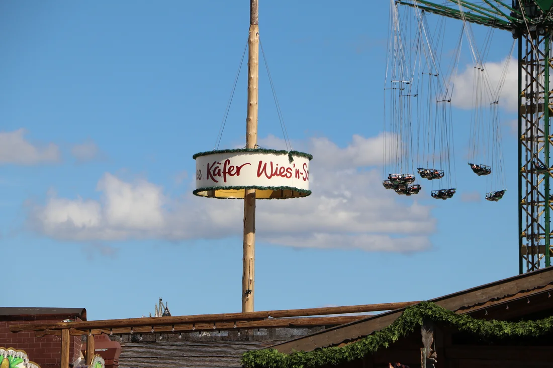 Werbeschild der Käfer Wiesn-Schänke am Maibaum auf dem Münchner Oktoberfest